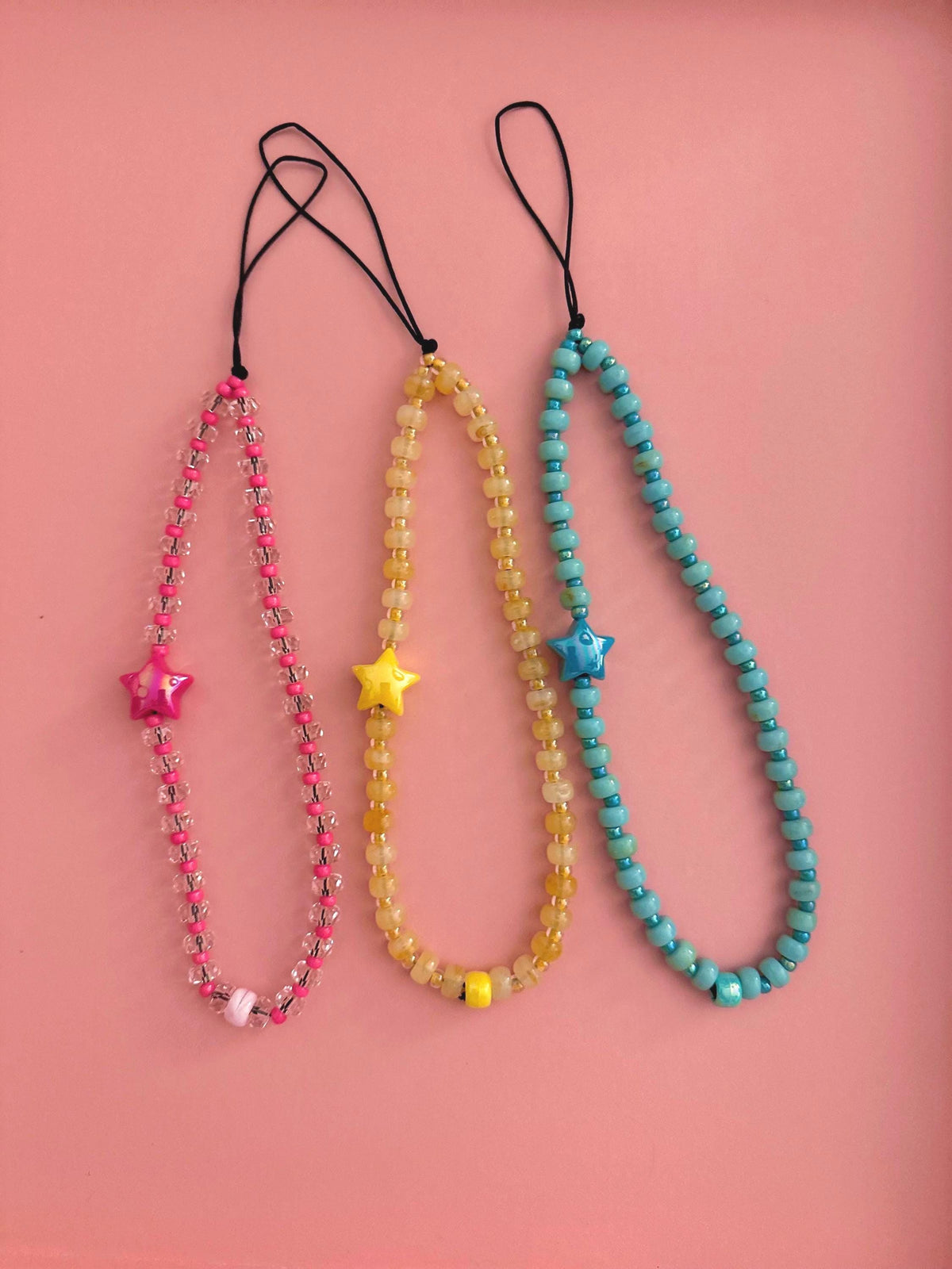 Pink, yellow, and blue cell phone straps with large focal star focal beads